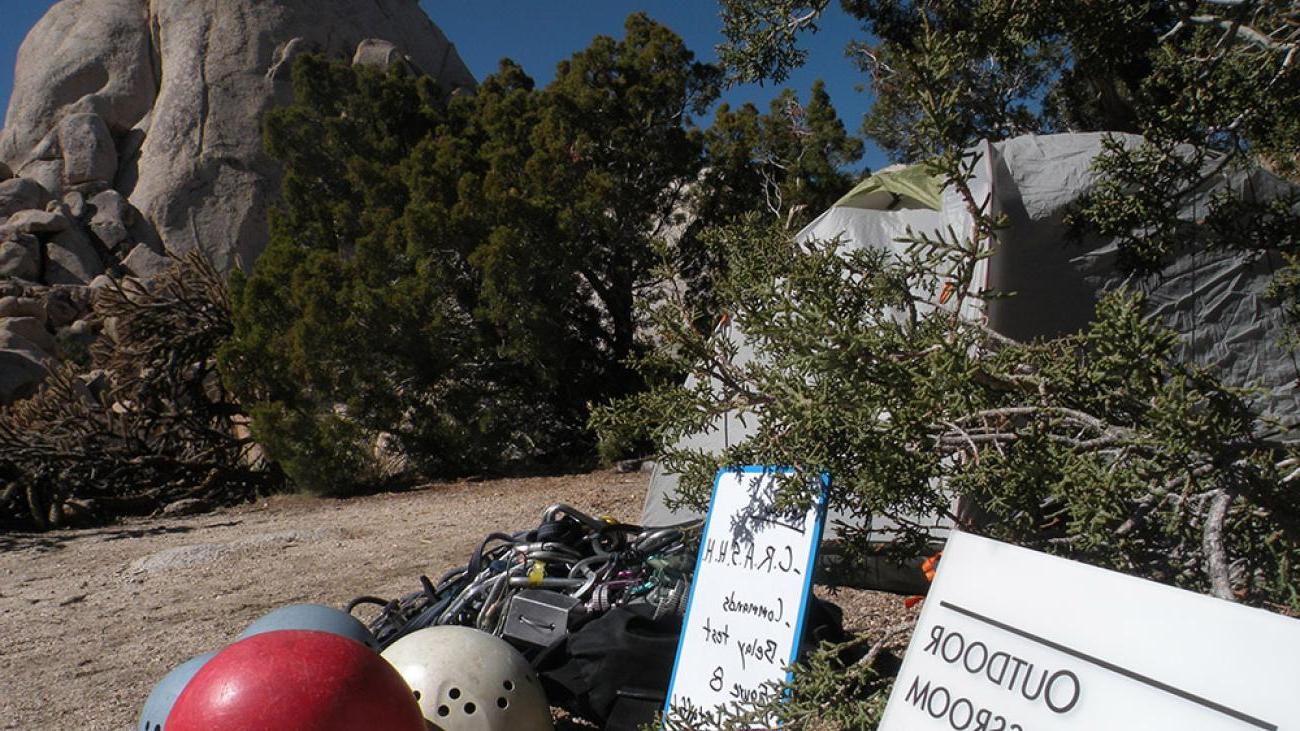 Helmets sit on a path outside a tent